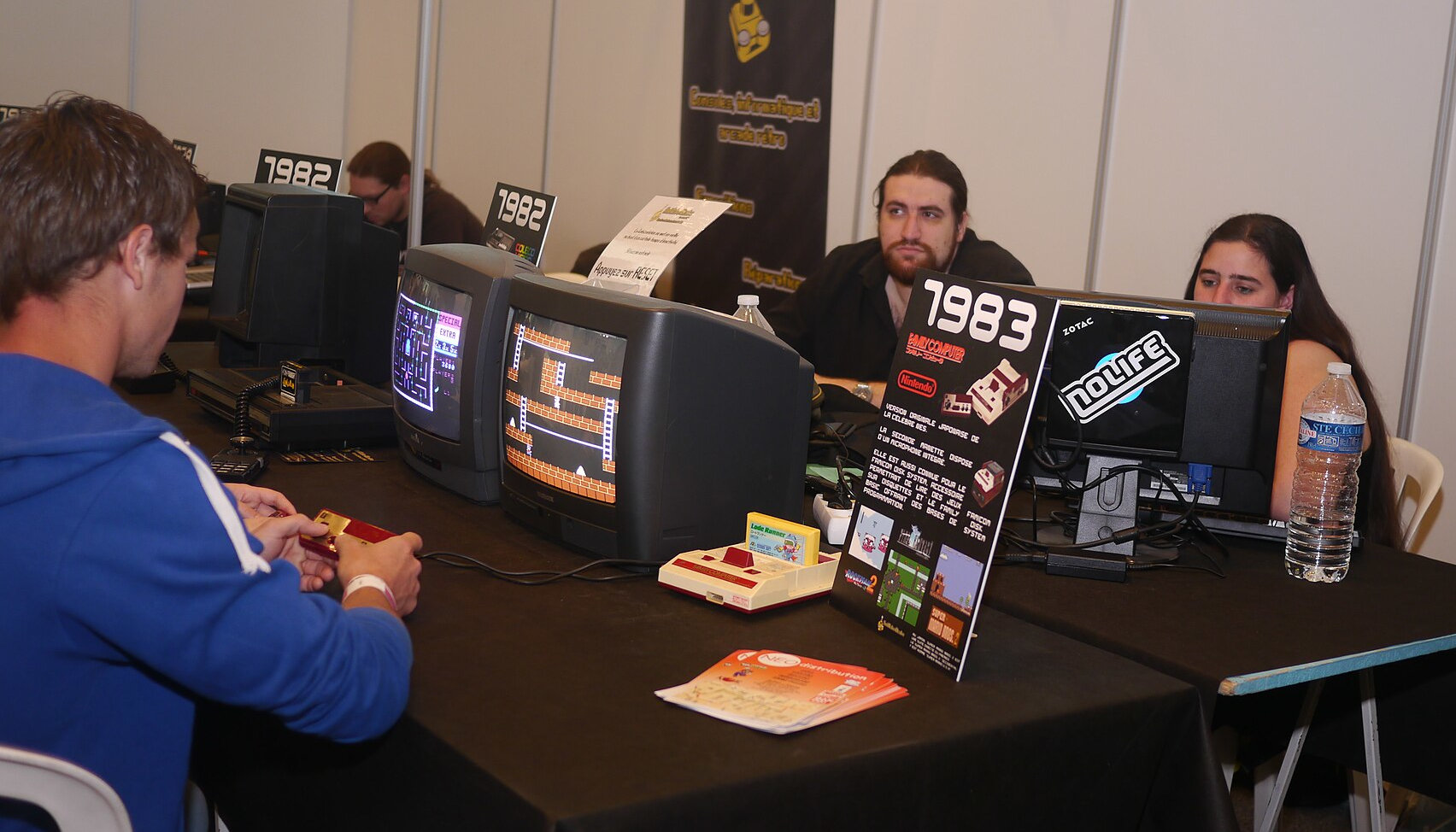 People playing on retro gaming consoles at an event